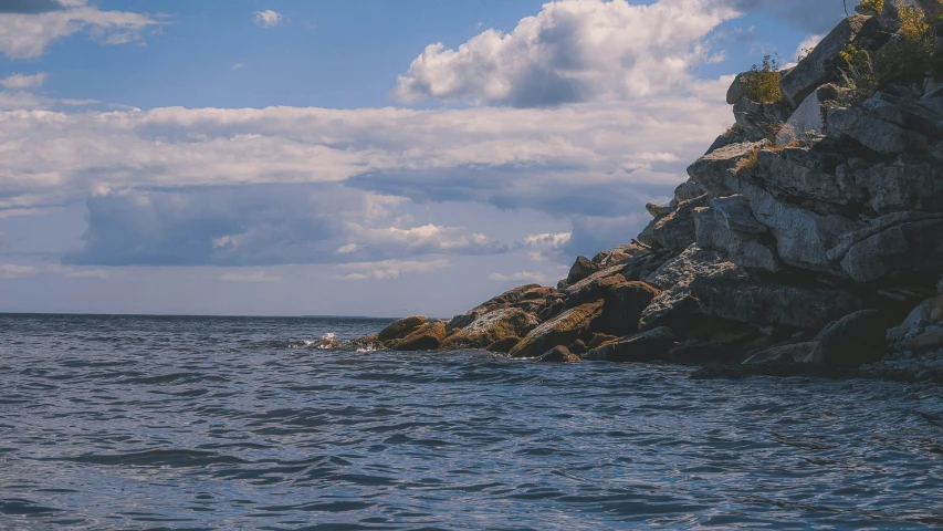 rock island in the water near a large cliff