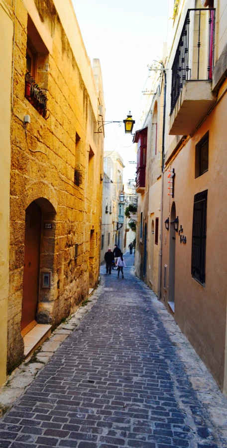 a cobble stone street leading into a small alley way