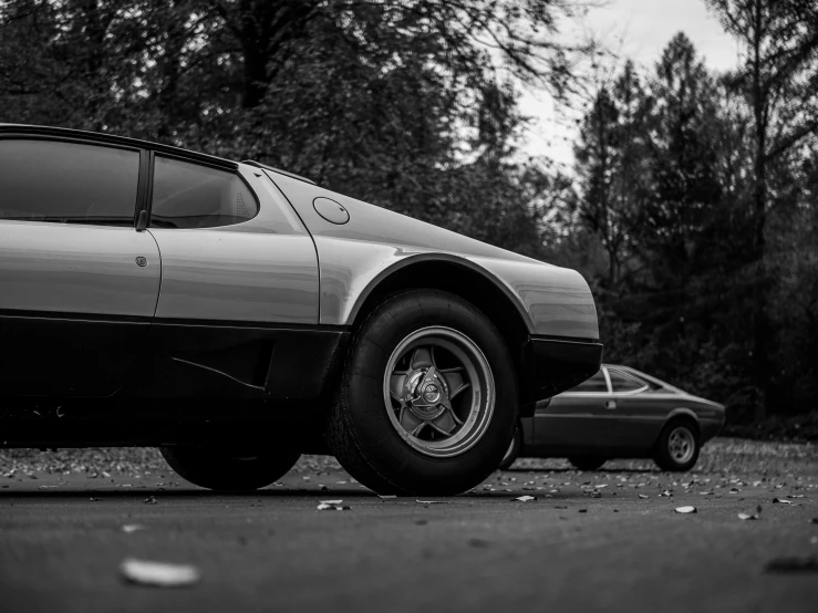 an old car is parked in a lot near some trees