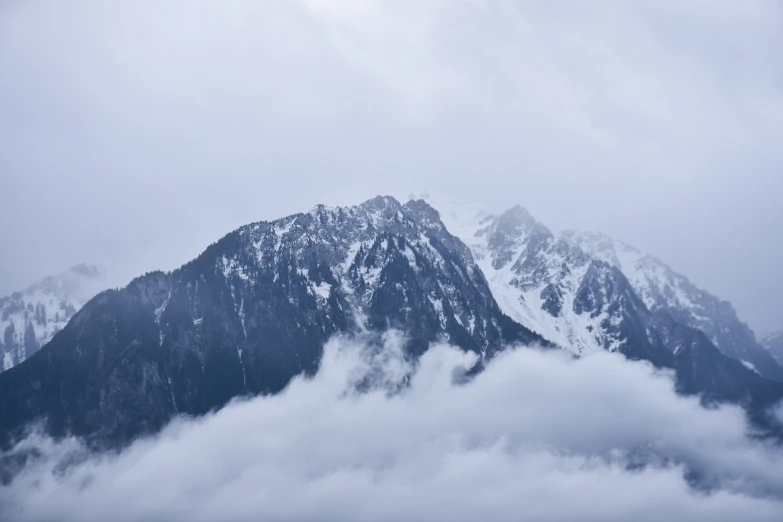 some clouds and snow covered mountains in the sky