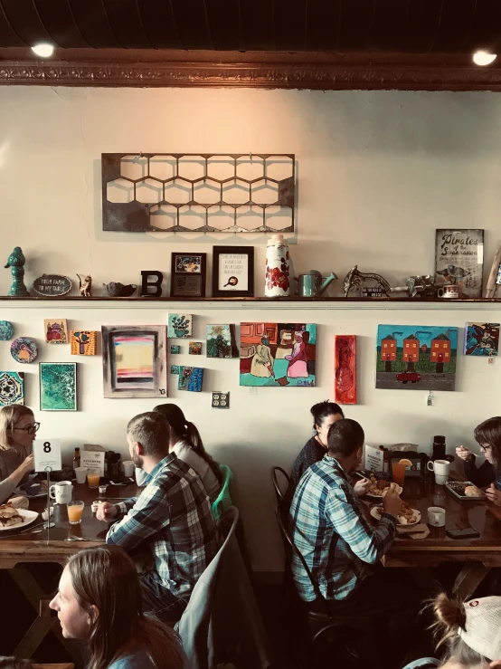 group of people sitting at tables with food in a restaurant