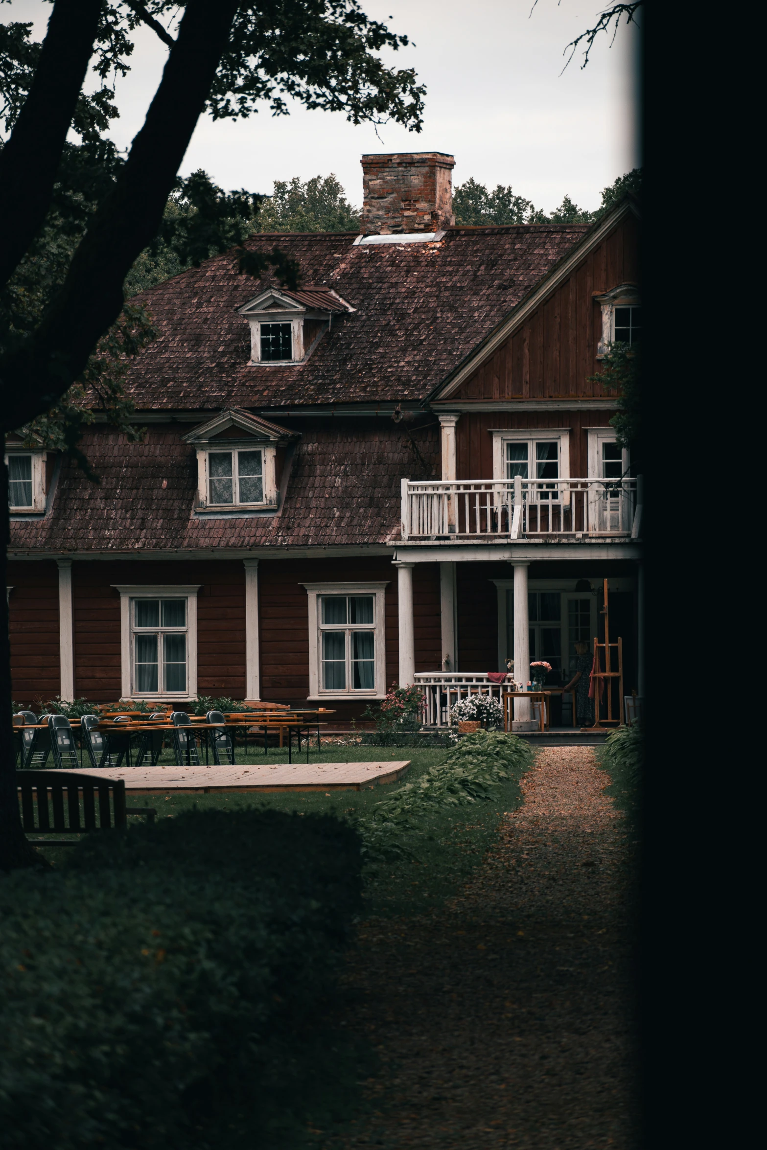 the view of an old house with wooden deck furniture