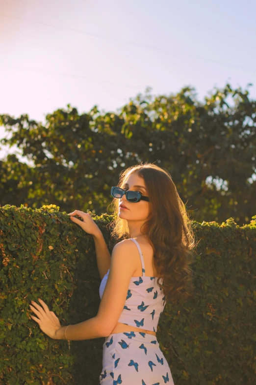 young woman looking up at bushes and smiling