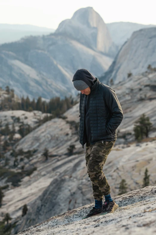 a man with winter wear looking at soing off a cliff