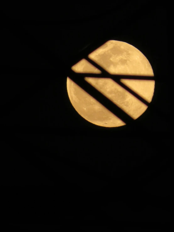 the moon through a round window with only one light on