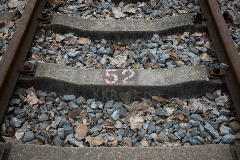 a number on some rocks beside some railroad tracks