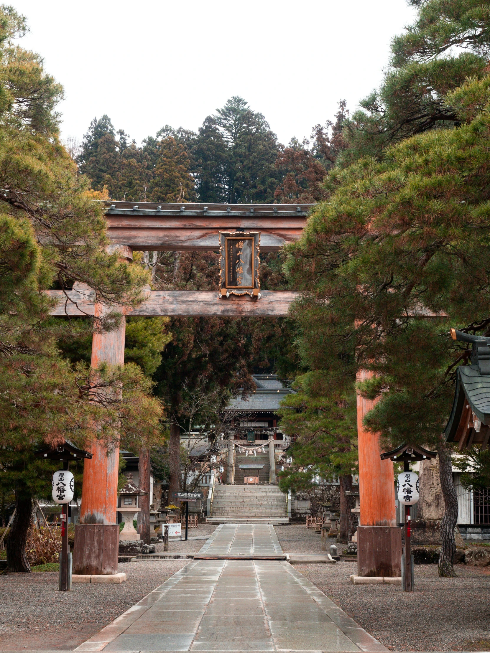 an open gate with many wood poles around it