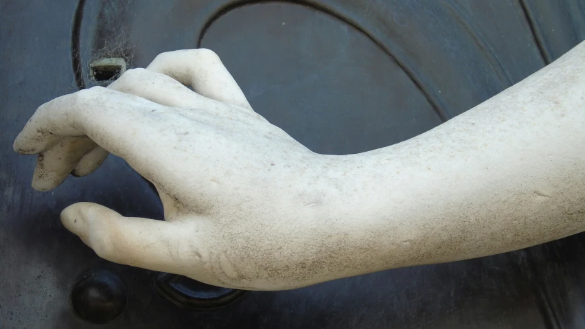 hand holding door knock, on a dark background