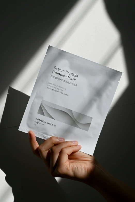 someone holding up a sheet of paper with a business card