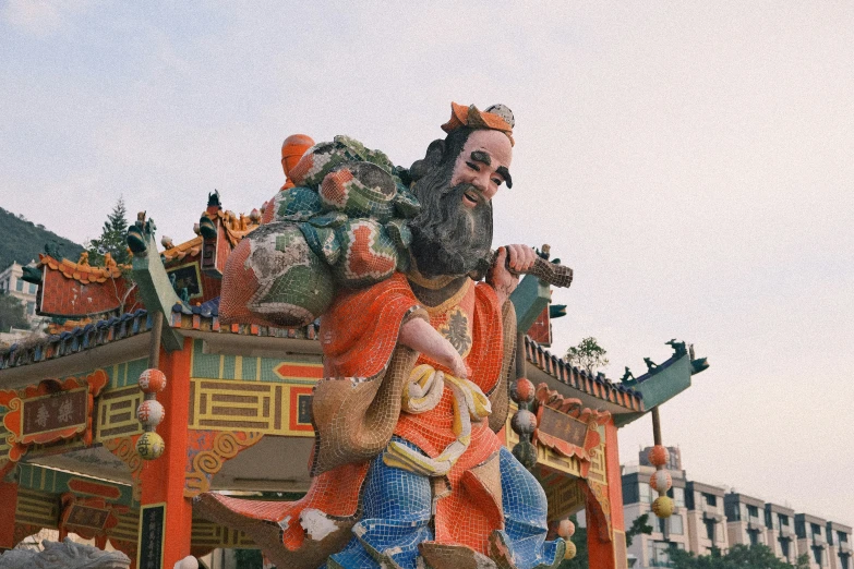 a giant statue on top of a building with mountains in the background