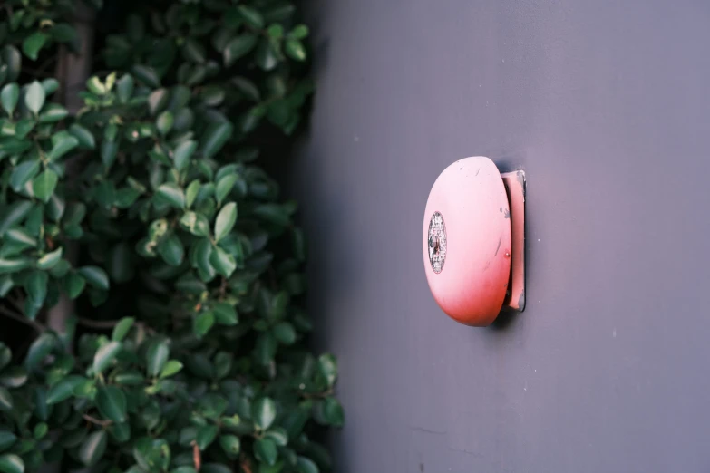 the pink object is attached to the gray wall