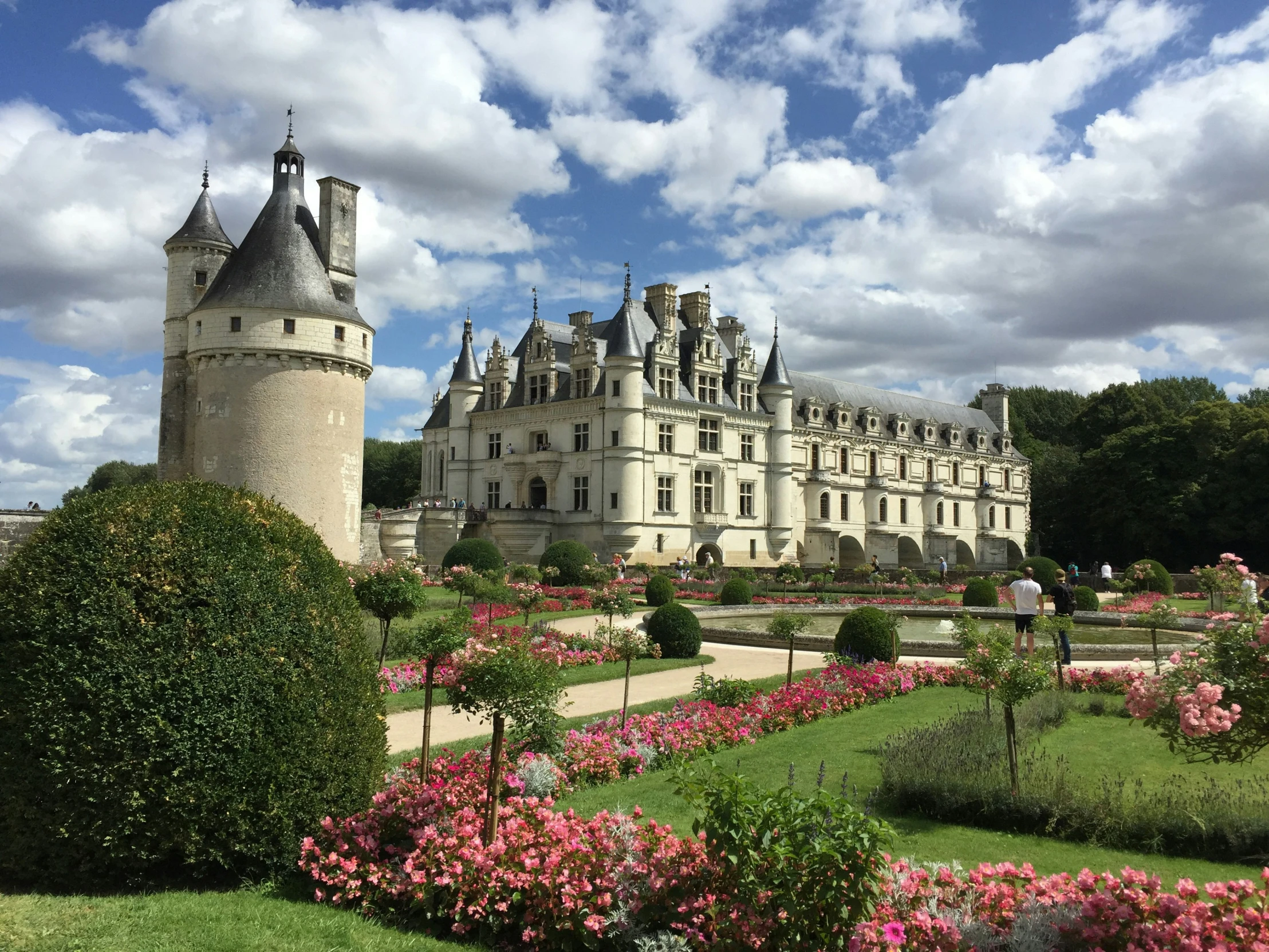 a castle surrounded by a lawn with a statue