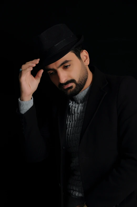 a man with a top hat on sits against a black background