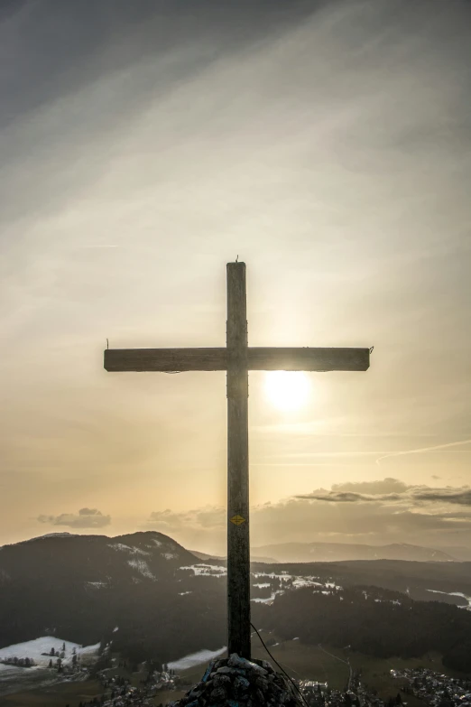 a cross stands on top of a hill