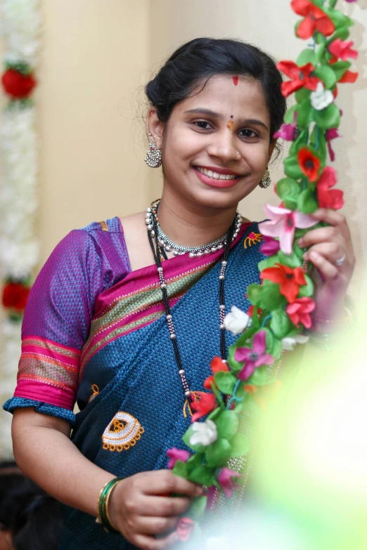 woman wearing traditional dress holding a flower decoration