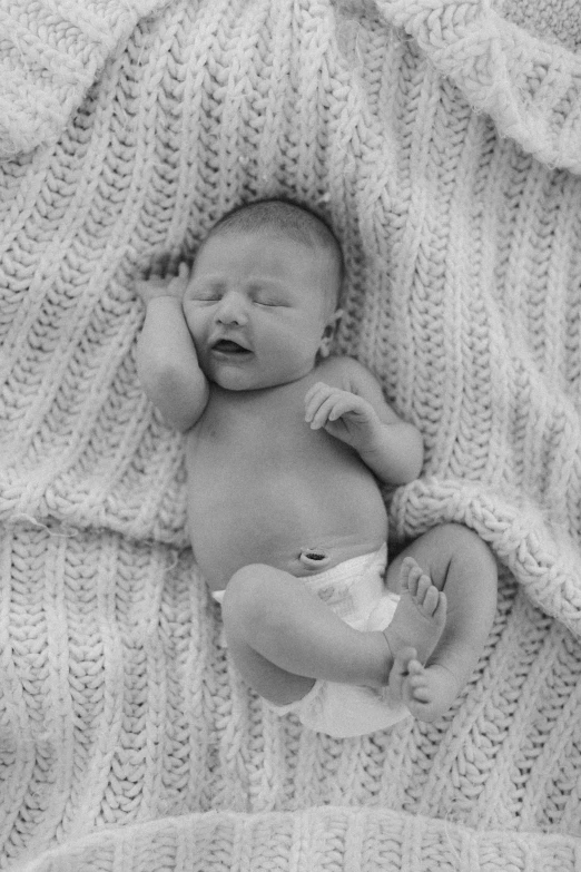 a baby laying on top of a blanket