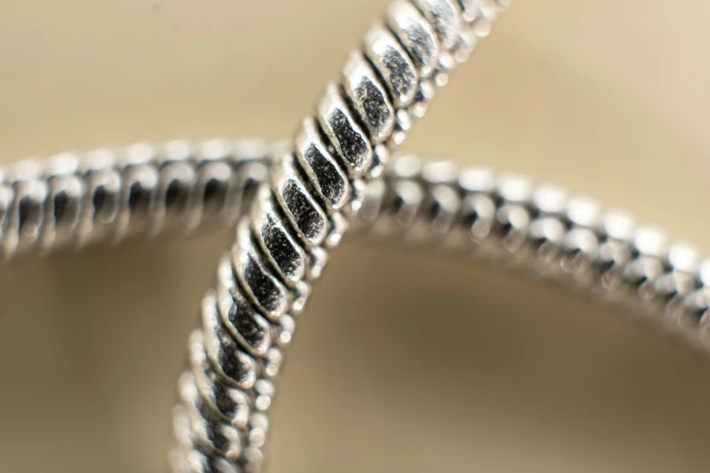 two silver strings attached together to an object