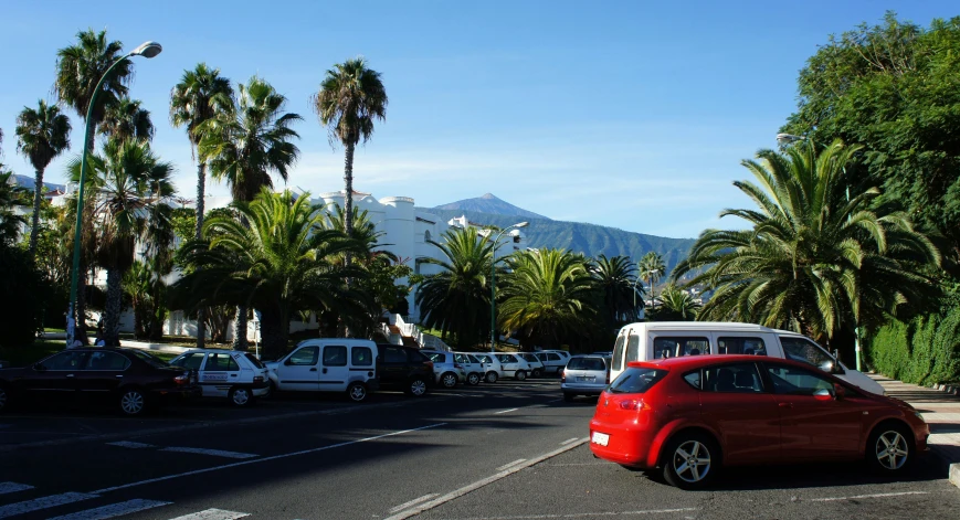 a red car sits in the middle of the street as other cars wait