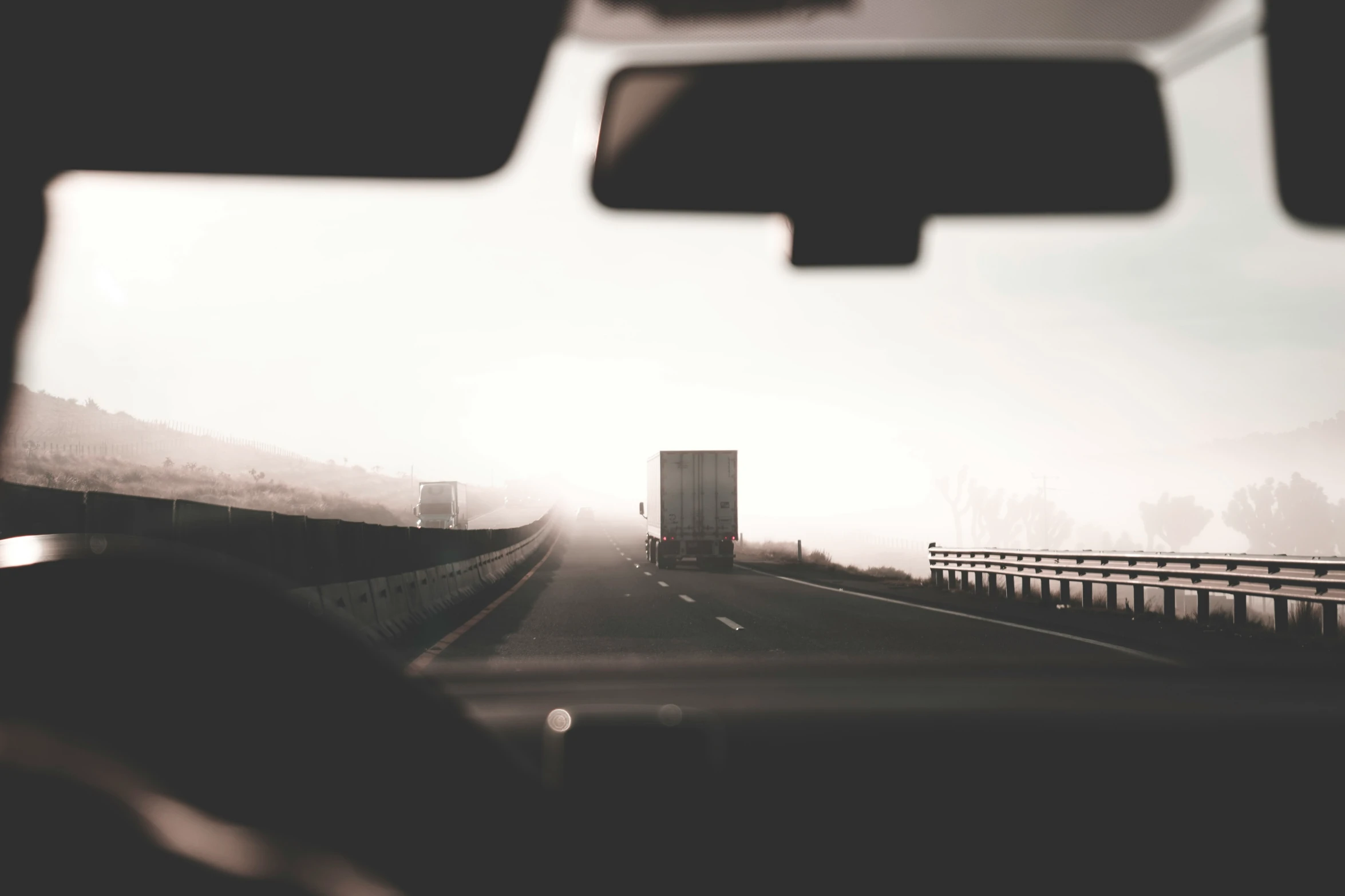 some cars driving on a foggy highway