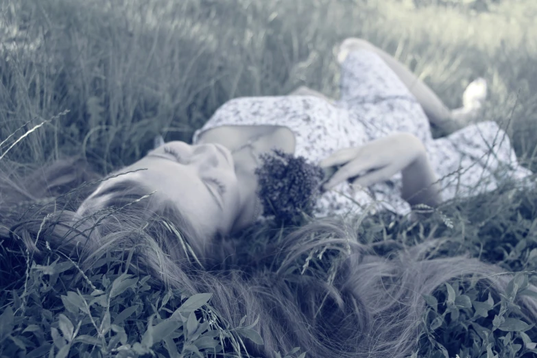 a woman laying in a field laying on her stomach