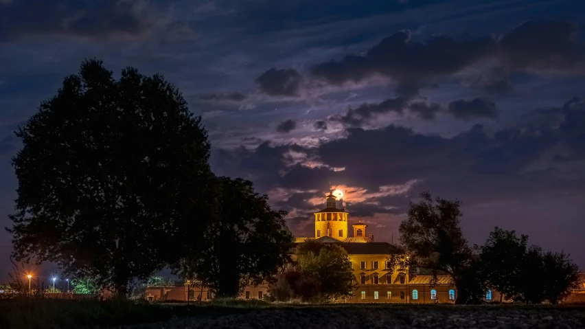 an illuminated clock tower sits beneath the evening sky