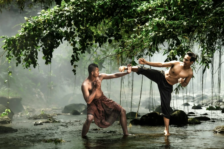 two men doing acrobatic poses in the river