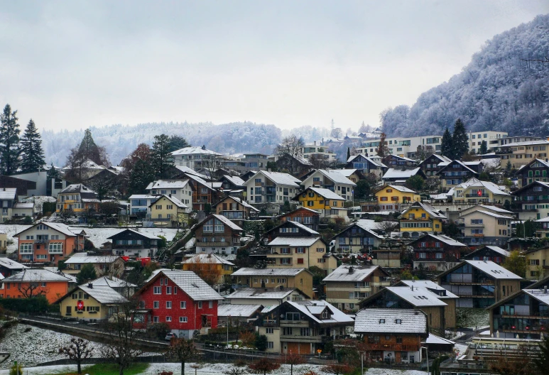 many colored houses with snow covered mountains in the background