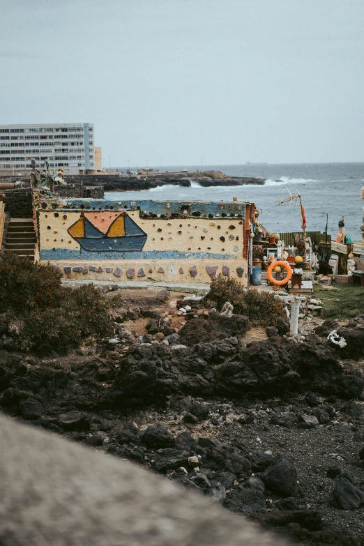 a cement walkway leads to some graffiti on the sea shore