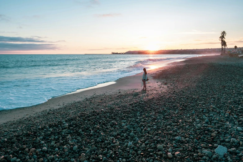 an image of a person walking alone at the beach