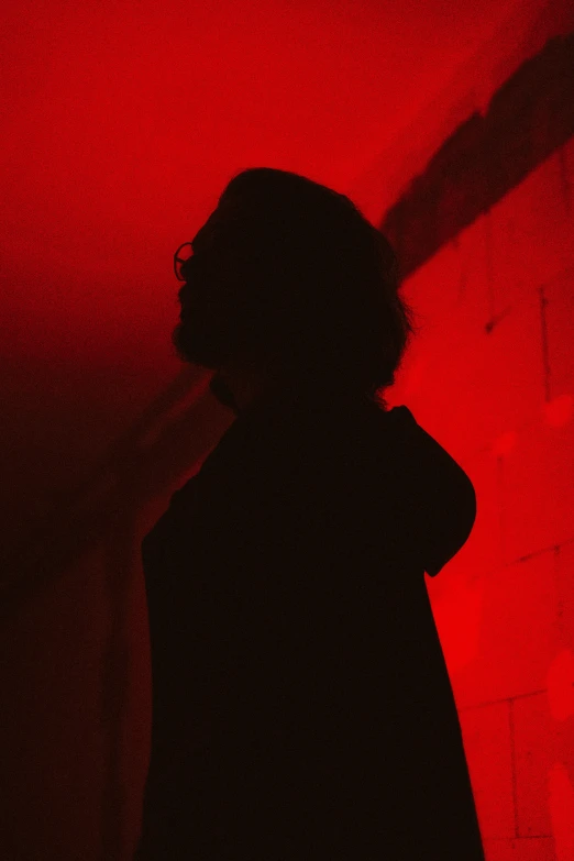 a woman is standing in a room with red lighting