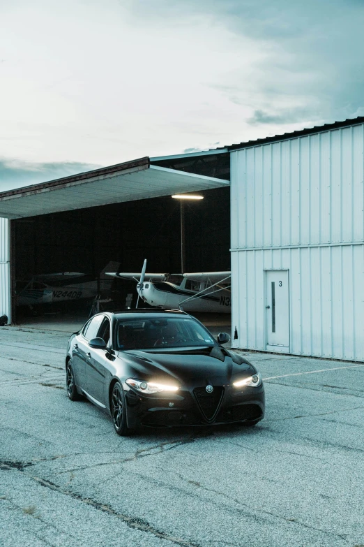 an image of a sports car parked in front of a airplane