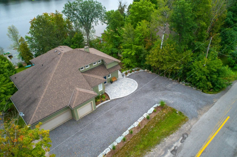 an aerial view of a house with a lot to the side and trees in front