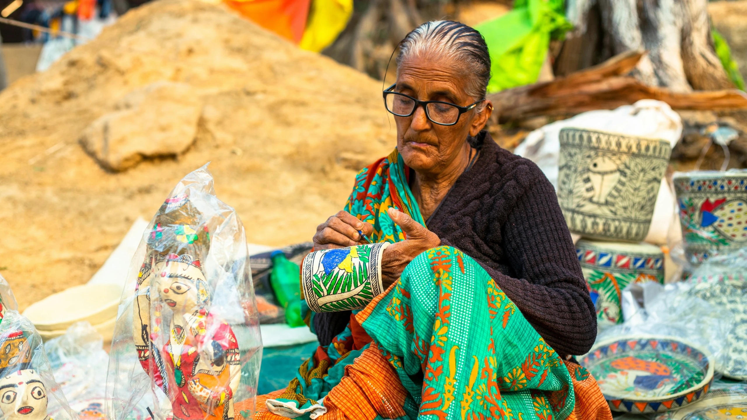 an older woman working on crafts at a market