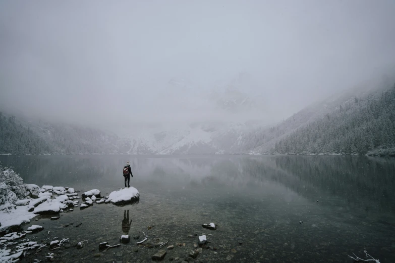 there is a person standing on the edge of a body of water