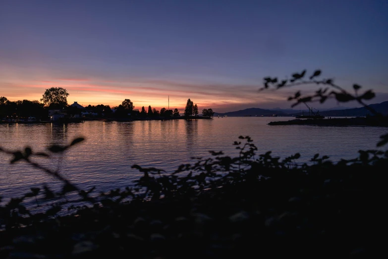 a lake with a sunset and boats on it