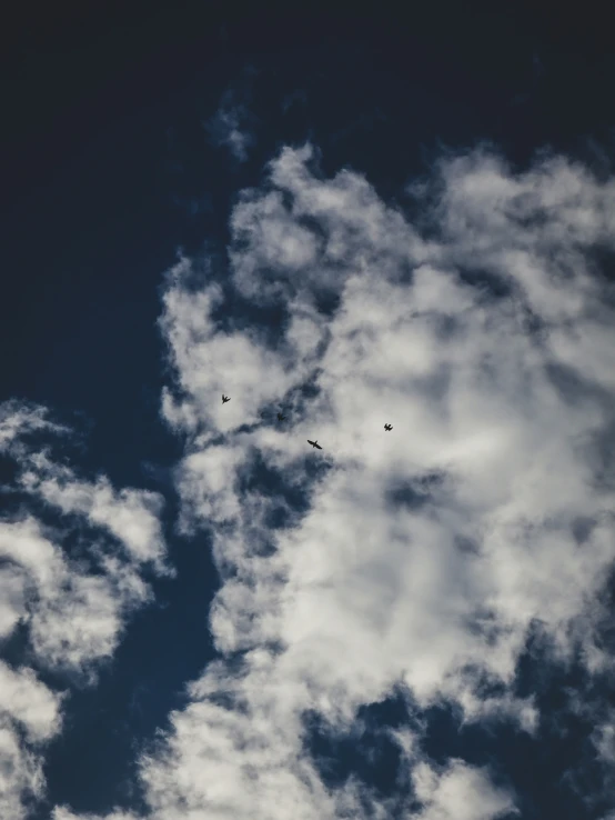 there is some clouds in the sky with two planes flying