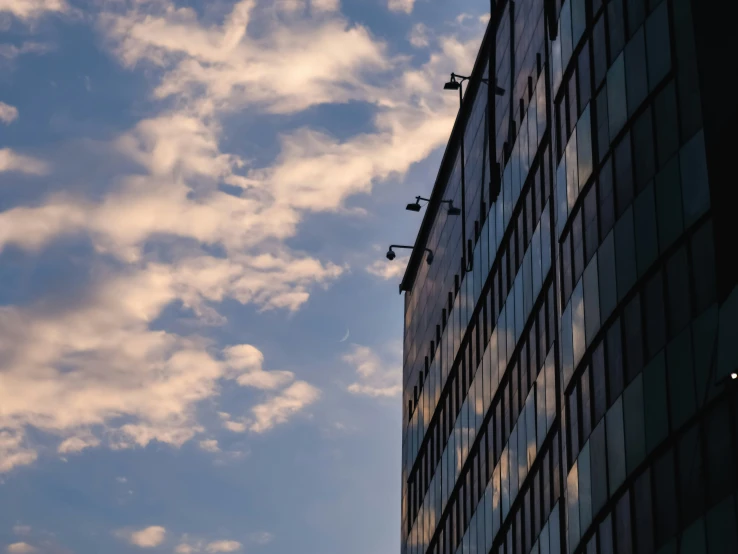 an airplane flying through a cloudy sky above a building