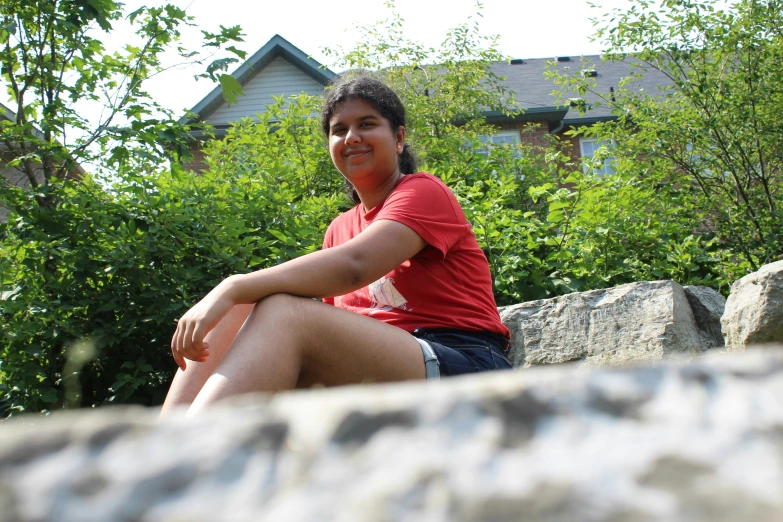 a person sitting on a stone surface with some trees
