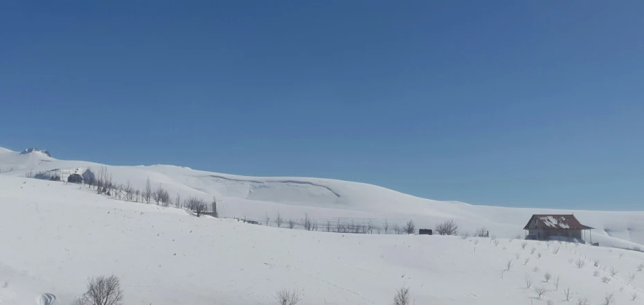 skiers are walking up the side of a snowy hill