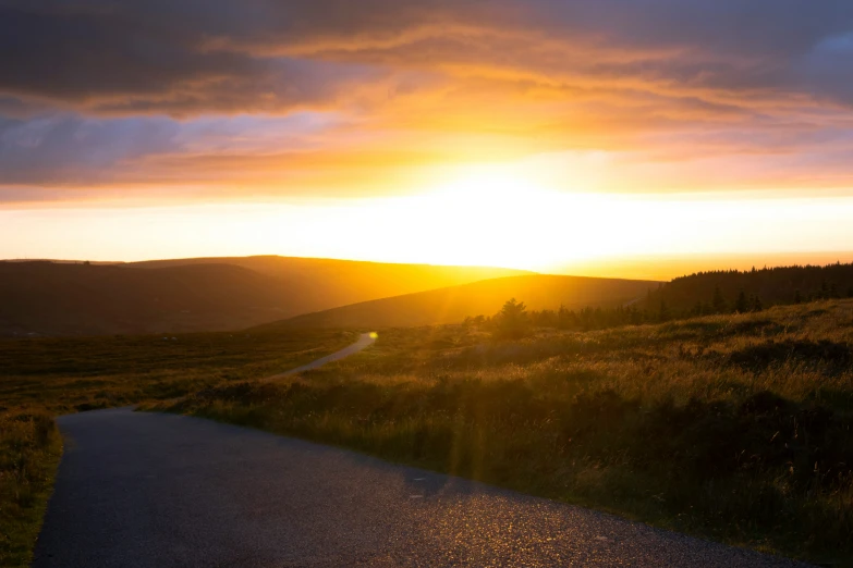 the sun is setting over a rural area