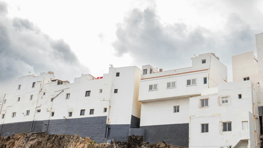 a long white building stands on the side of a hill