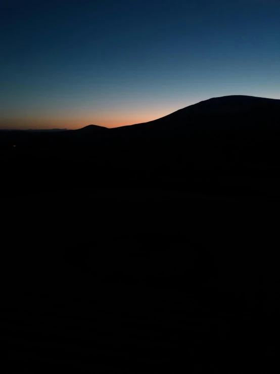 a lone person on top of a mountain at night