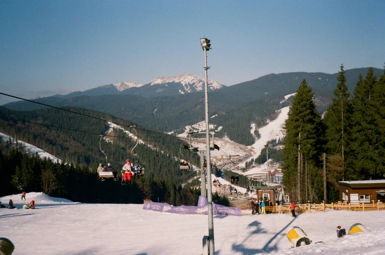 some skiers on a snowy hill trees and buildings