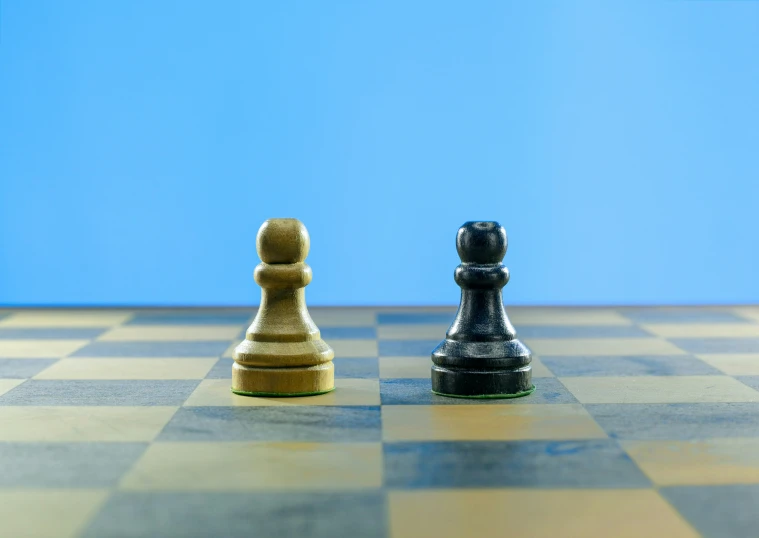 two chess pieces sitting on a chess board