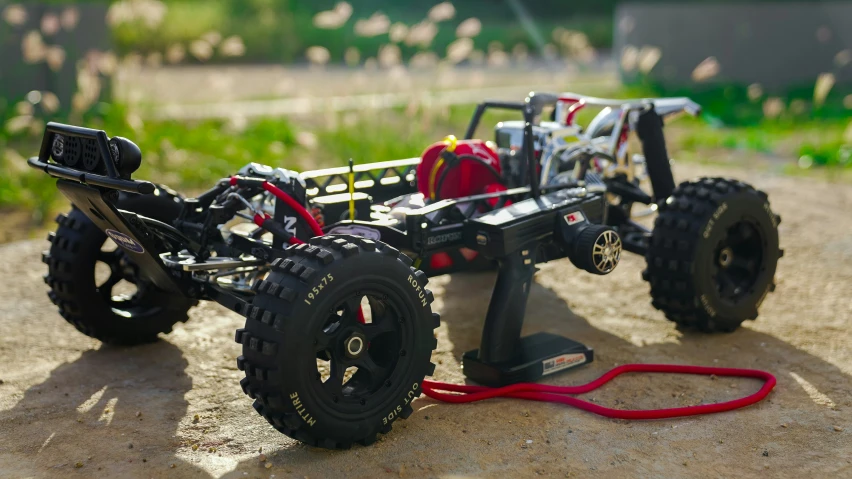 a small radio controlled toy vehicle sitting on a dirt road