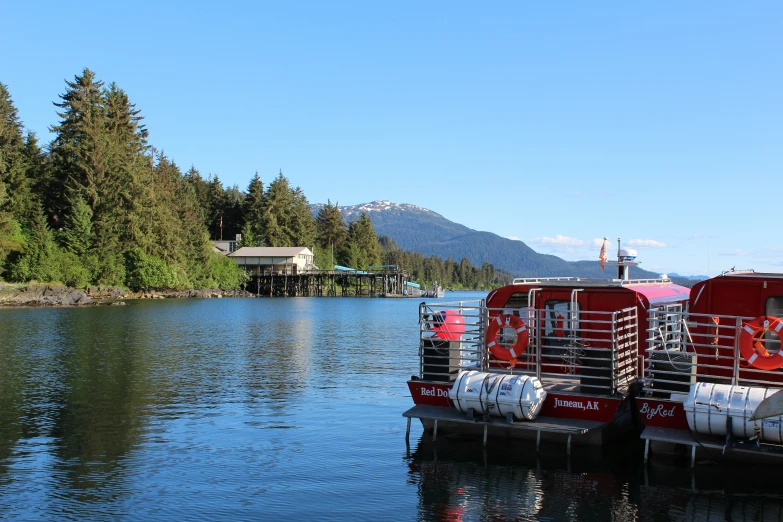 a line of red boats sit on a large body of water