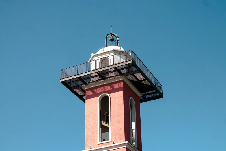 a tall red clock tower with a black roof