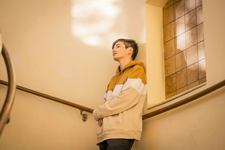 a boy is standing on the stairs in a building