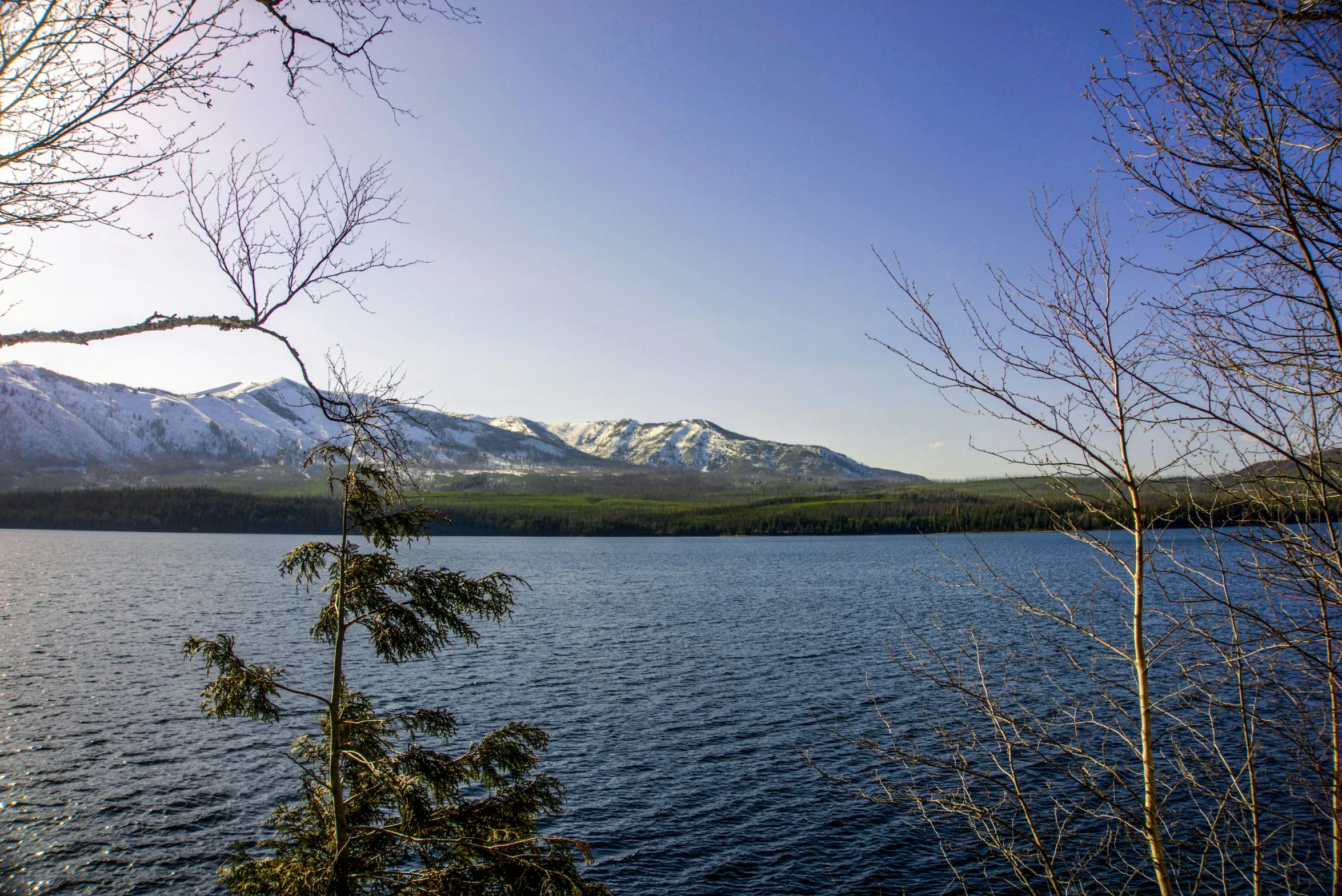 a lake with snow capped mountains in the background