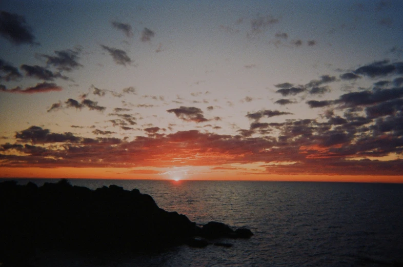 a sunset with some clouds that are red and yellow